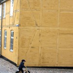 roskilde-boy-on-wooden-bike-yellow-house