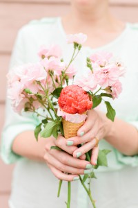 woman holding strawberry rose sorbet in her hands with a bouquet of roses