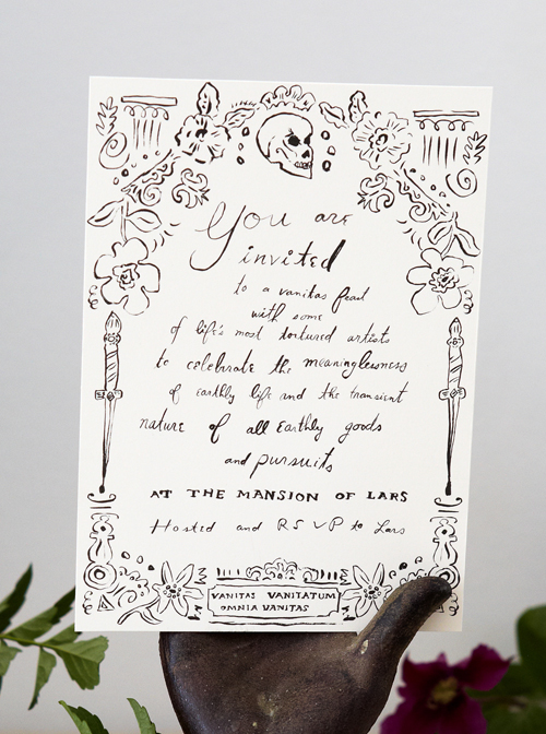 black and white illustrated halloween party invitation in a black decorative hadn surrounded by foliage and fruits