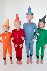 Four kids wearing crayon halloween costumes in orange, red, blue, and green.