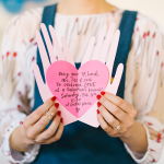 Hand holding heart pop up valentine
