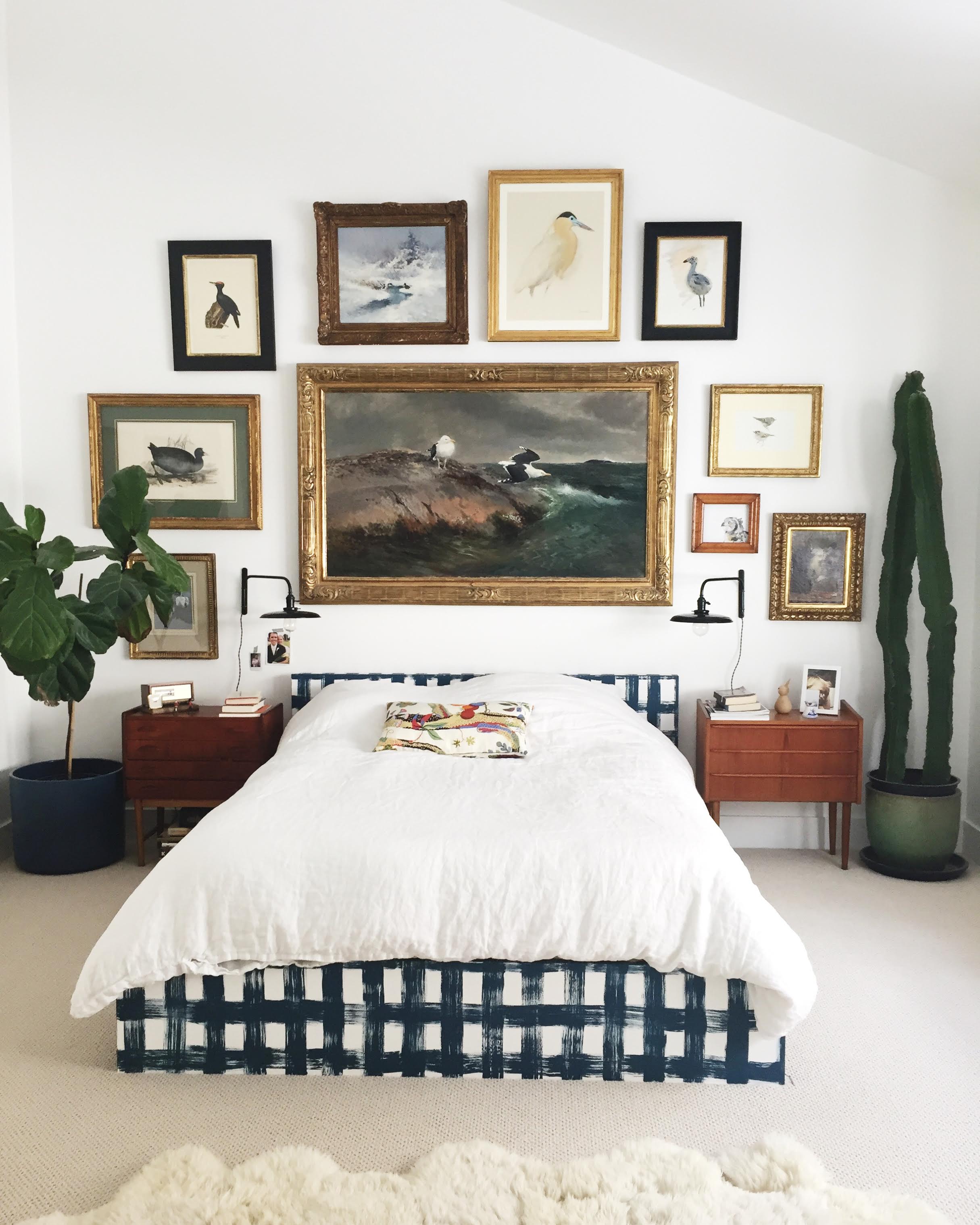 An installed gallery wall over a bed