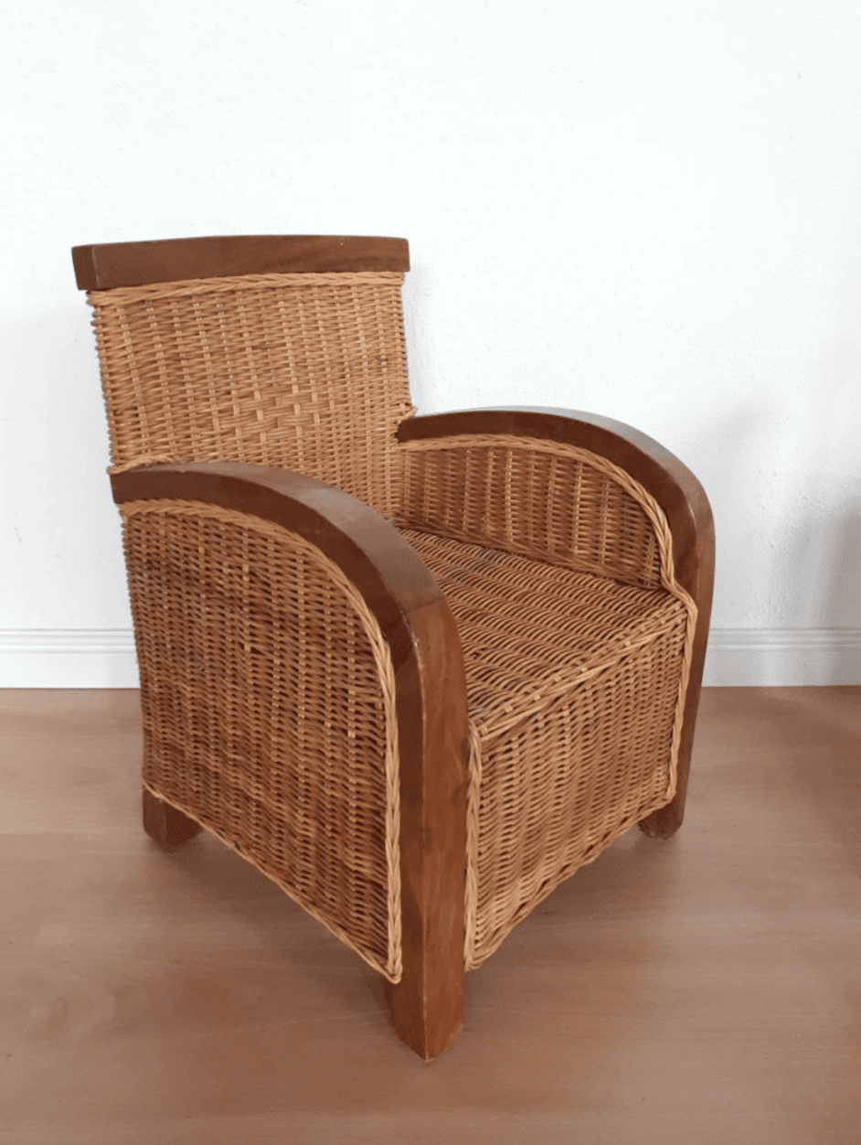 A rattan and teakwood antique armchair for kids in a white room.