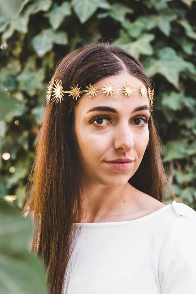Hailey wearing a white top and a gold star crown.