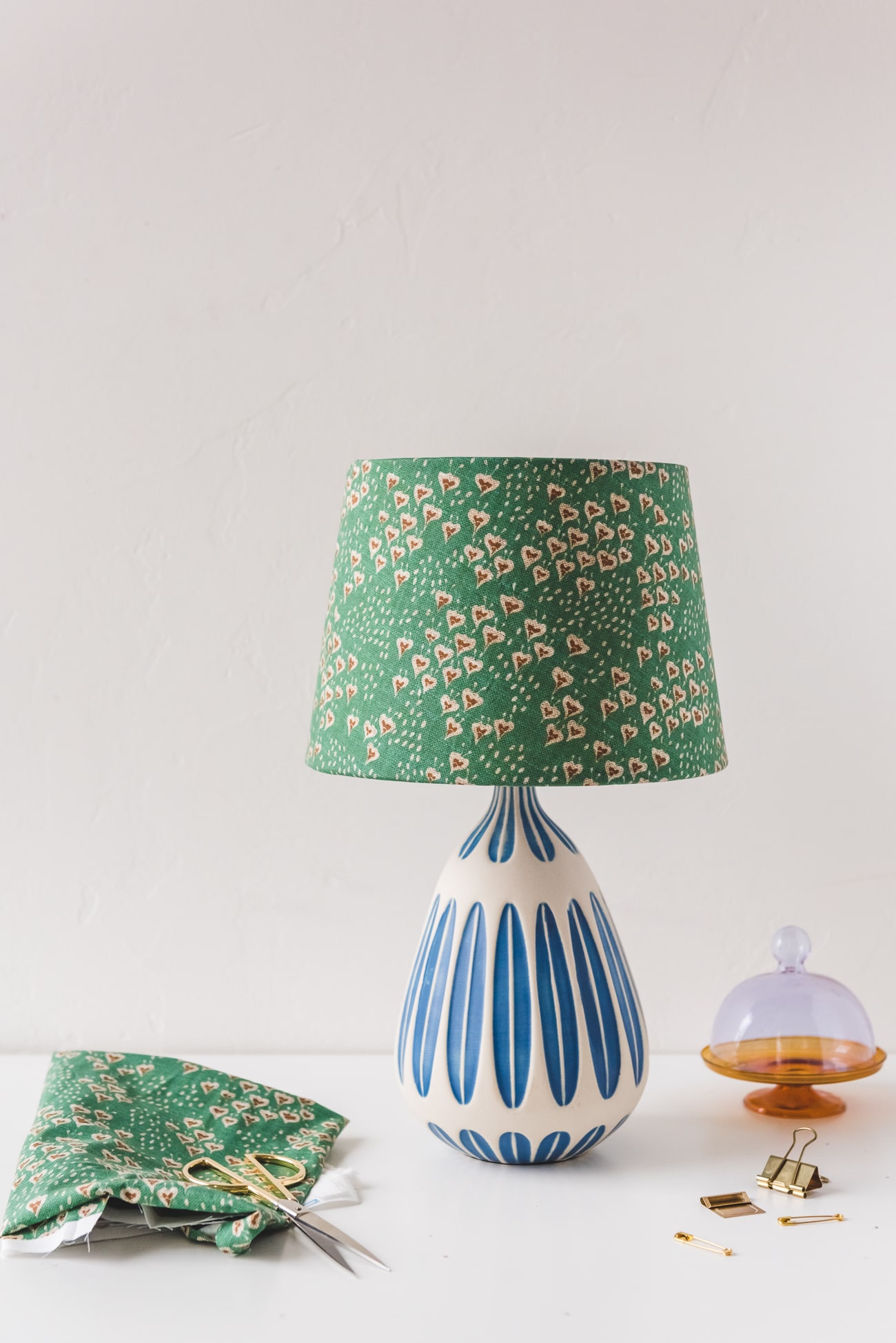 Lamp customized with spoonflower fabric from Holli Zollinger against a wildflower covered wall.