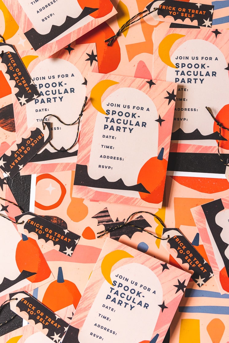 Paper party goods with a halloween theme on a black background. They're orange, yellow, black, white, navy, and peach.