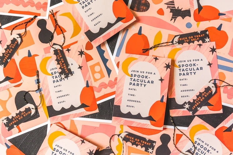 Halloween party invitations, placemats, place cards, and party tags arranged on a table