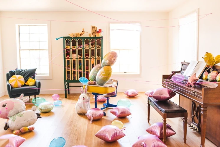 Interior shot of an Easter Scavenger Hunt. Balloons are strewn around the room and string zigzags across the space.