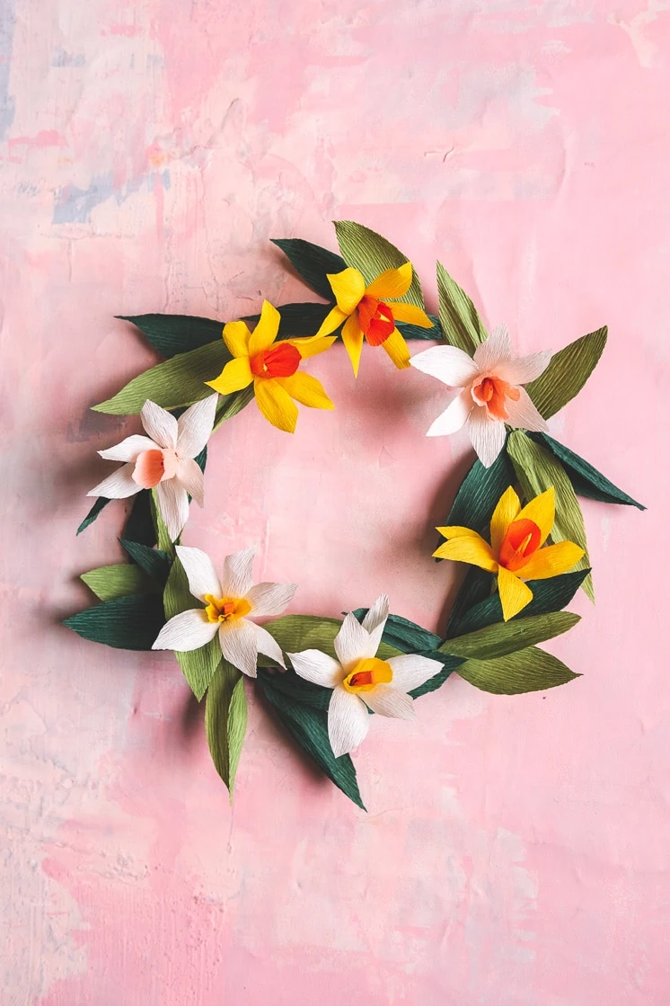 Paper daffodil wreath against a pink background