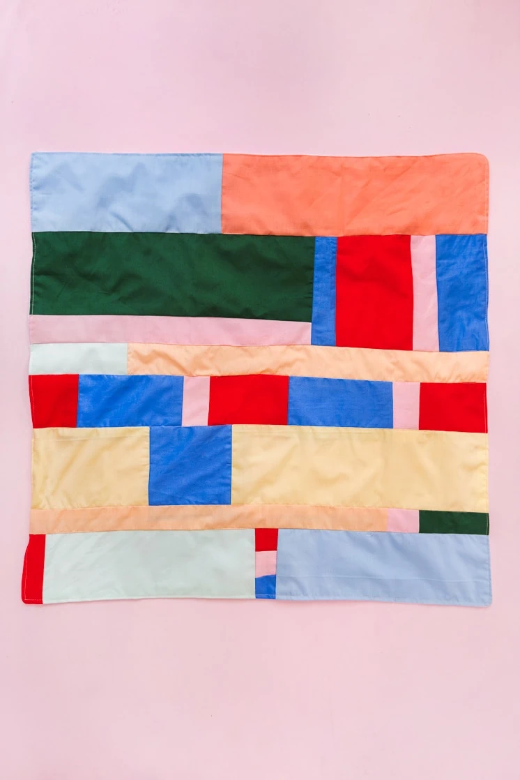 colorful patchwork bandana on a blush background.