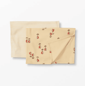Two burp cloths on a white background. One is yellow and white striped and one is yellow with little red tulips.