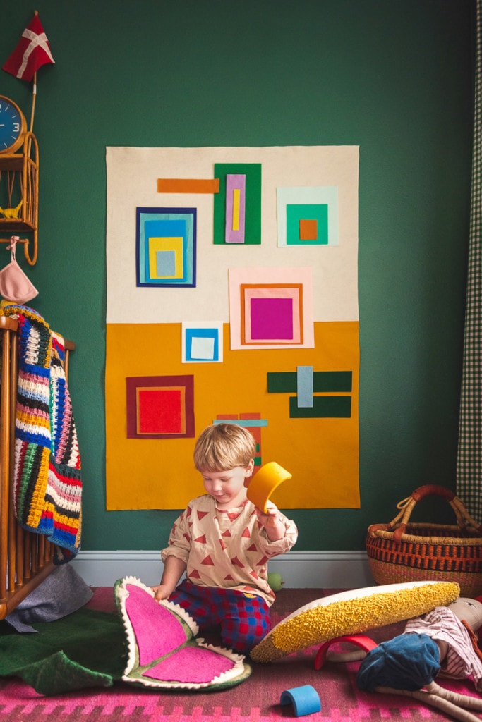 Jasper playing with an Albers-inspired felt board in a colorful room