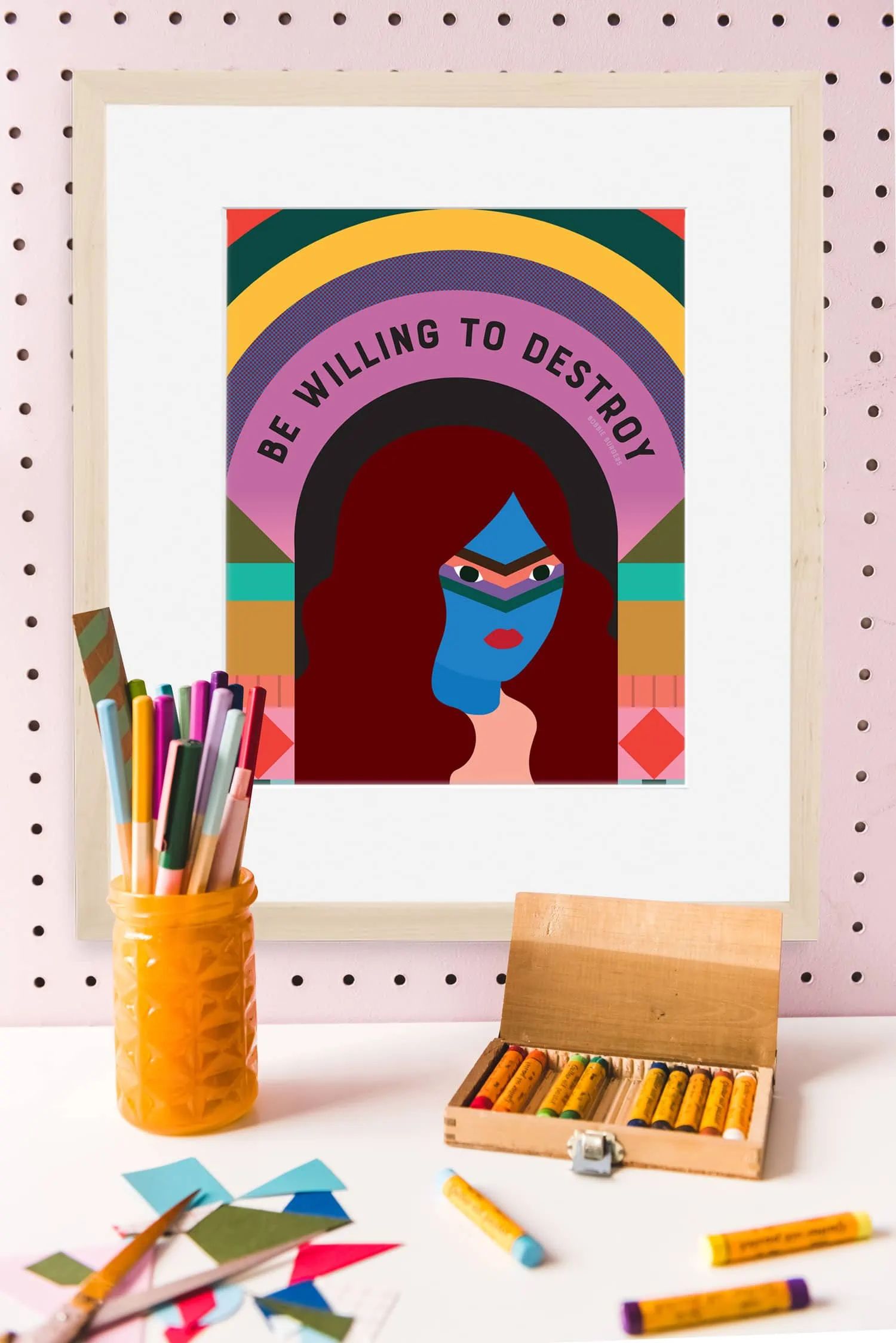 Graphic portrait of a woman with the text "be willing to destroy" among art supplies on a pink wall
