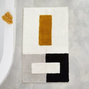 A grey, white, black, and gold colorblock bath mat