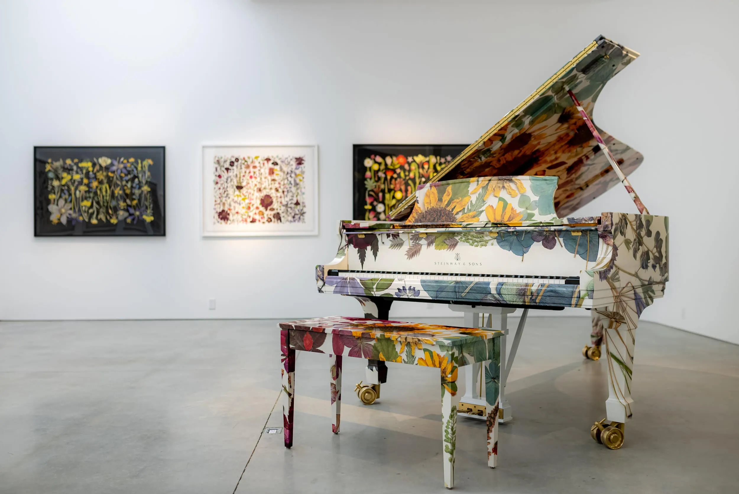 A botanically wrapped Steinway piano in a white gallery with botanical flower prints on the walls