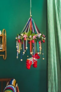 A colorful chandelier with a hanging Dala horse is i