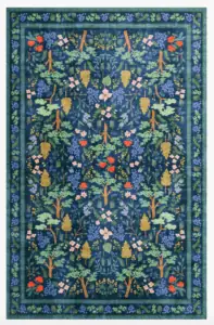 An intricately patterned rug in blues, greens, and pops of pinks, mustard, and pink.