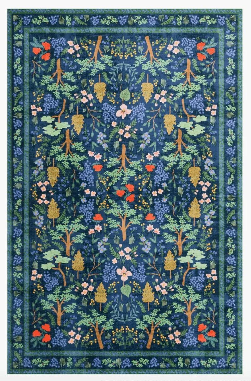 An intricately patterned rug in blues, greens, and pops of pinks, mustard, and pink.