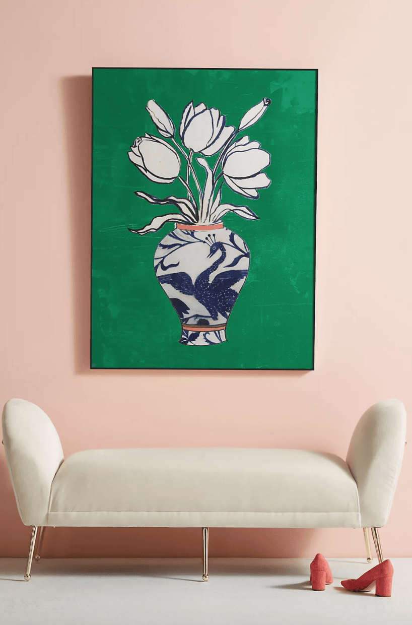 a bold green artwork on a blush pink wall over a white sofa