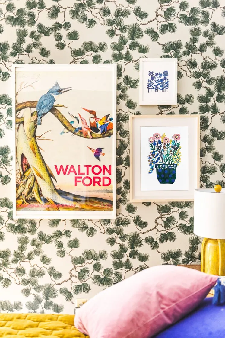 colorful art prints on a wallpapered wall