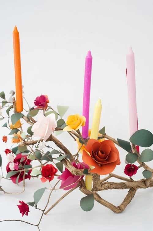 Paper flowers and colorful candles on a branch