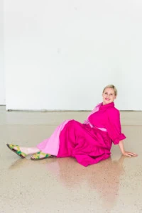 Brittany sits on her epoxied garage floor wearing a two-toned pink dress.