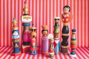 Midcentury painted heirloom nativity figures against a pink and red striped background.