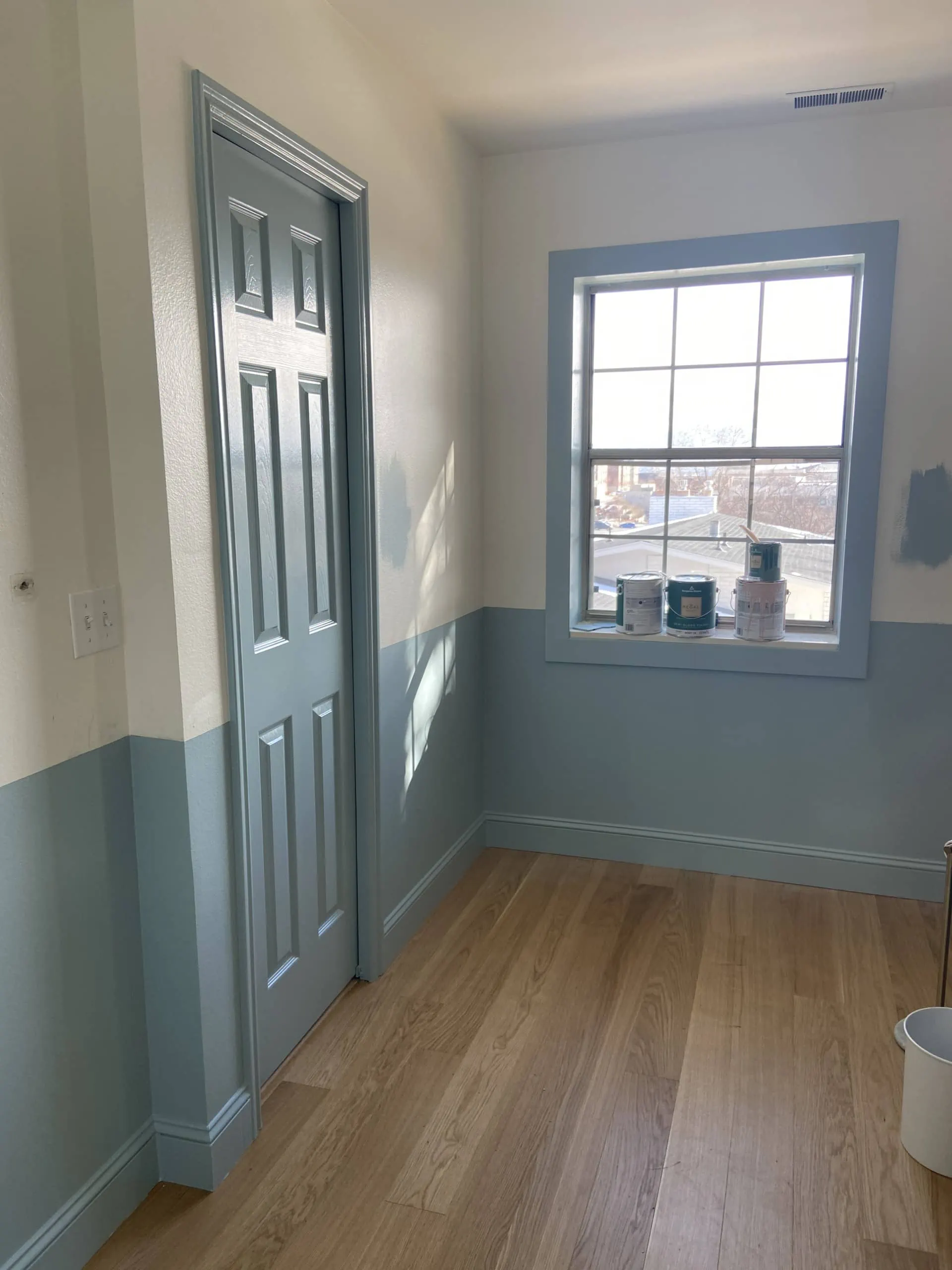 Interior shot of a room with wooden floors and blue and white walls.