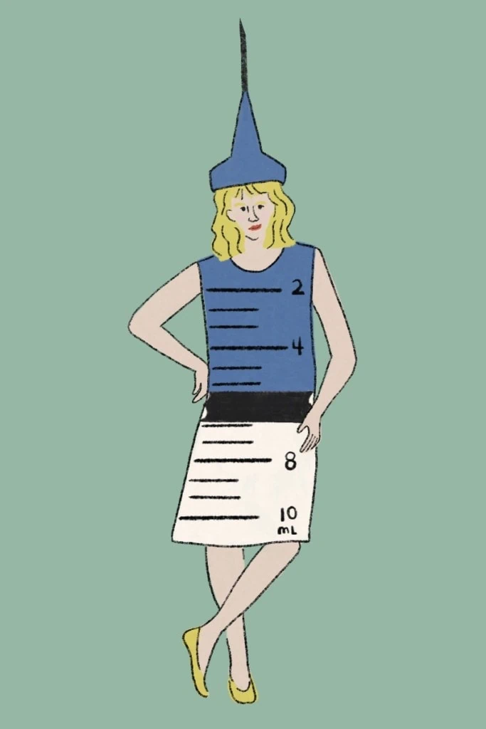 halloween costume of a vaccine illustration: a blonde woman wears a blue and white shift dress with numbers drawn on to look like a syringe. She's wearing a tall sharp hat that looks like a needle. The background is green.