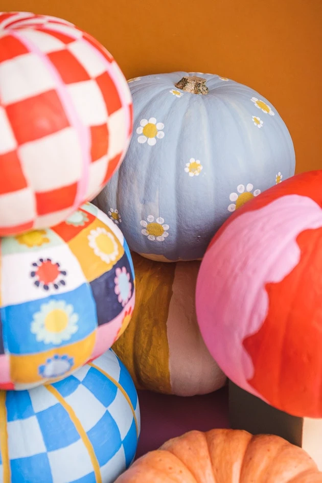 A clump of painted mini pumpkins in bright colors.