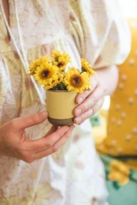 yellow mums in ceramic cup