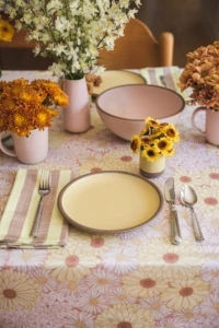 70s vibe brunch with yellow plates and floral tablecloth and fresh flowers