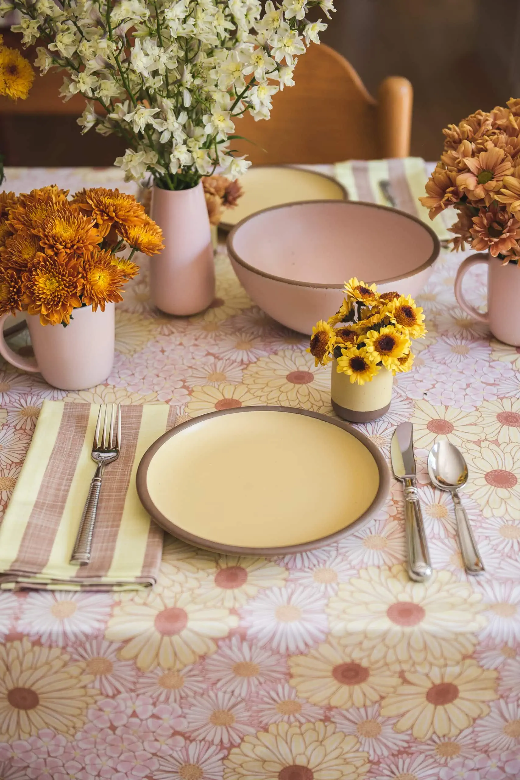 70s vibe brunch with yellow plates and floral tablecloth and fresh flowers