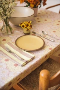 yellow plate ceramic with floral tablecloth and striped napkin 70s vibes