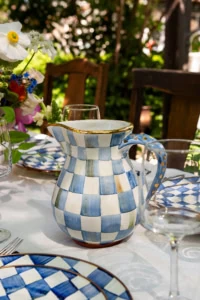 blue and white checkerboard plates on a tablle for a birthday party in a garden with beautiful flowers